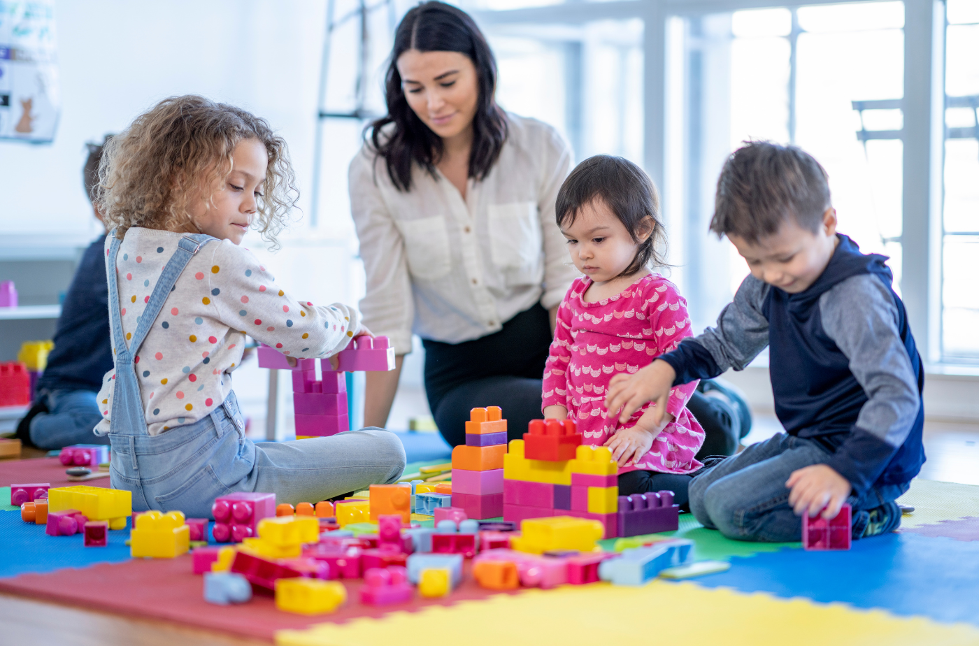 Im Lahn-Dill-Kreis werden 7.605 Kinder von 1.497 Fachkräften betreut. Foto: Childcare Provider Playing with Children von FatCamera; stock photo;Getty Images Signature via Canva.com