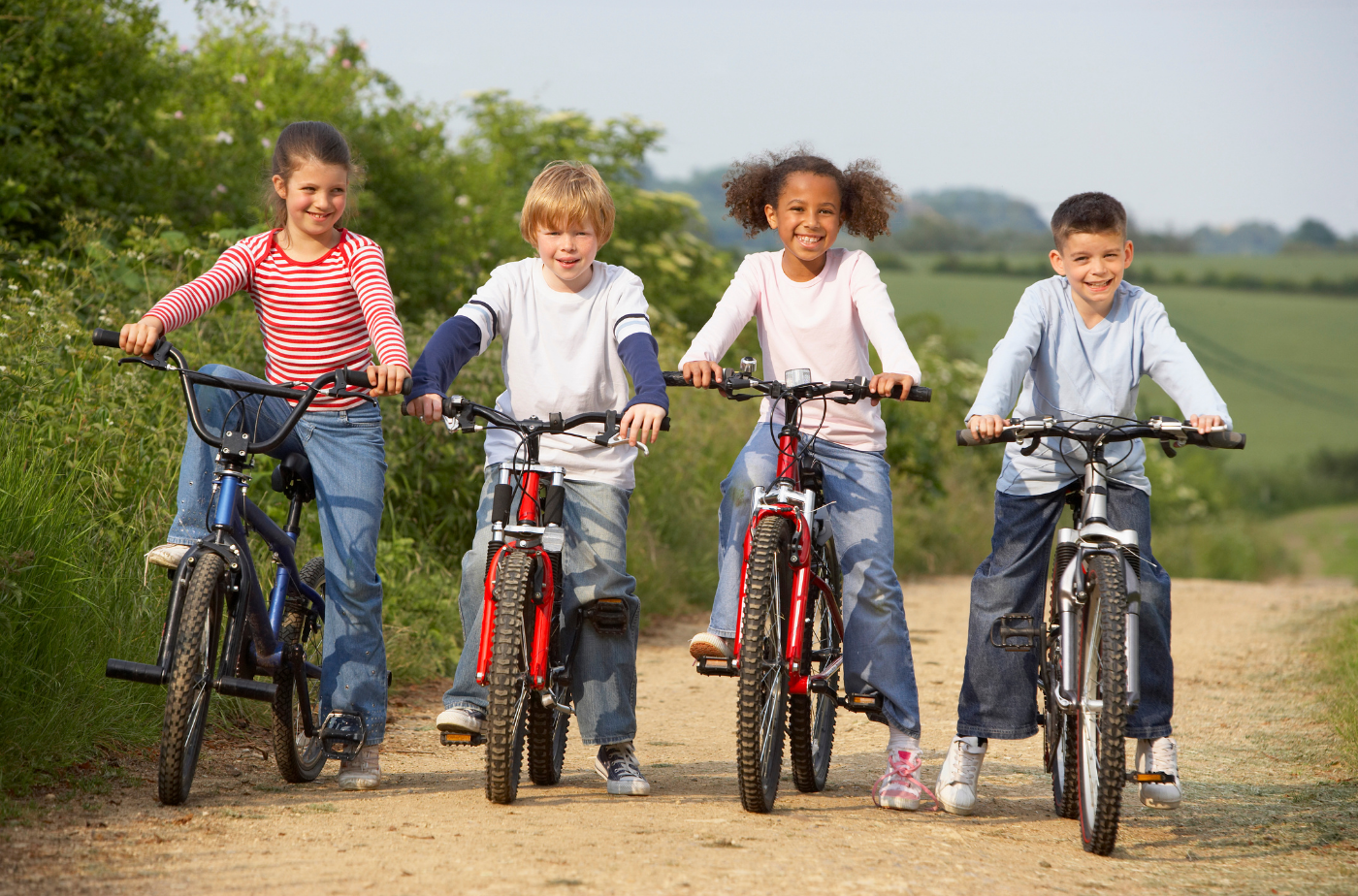 4 Kinder fahren draußen Fahrrad. Bis zum 30. Mai können die Materialien für die Teilnahme an der Kindermeilen-Kampagne kostenlos bestellt werden. Foto: Kids riding bikes outdoos von BananaStock von Photo Images via Canva.com