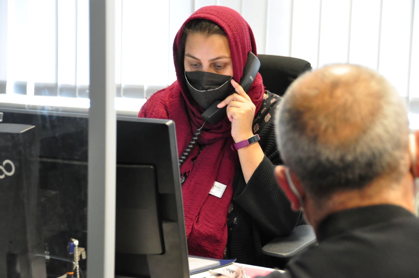 111_01 Asfa Masood berät einen Mann aus der Ukraine während der Sprechzeit im Flüchtlingsbüro. Er benötigt einen Arzttermin. Foto: Lahn-Dill-Kreis