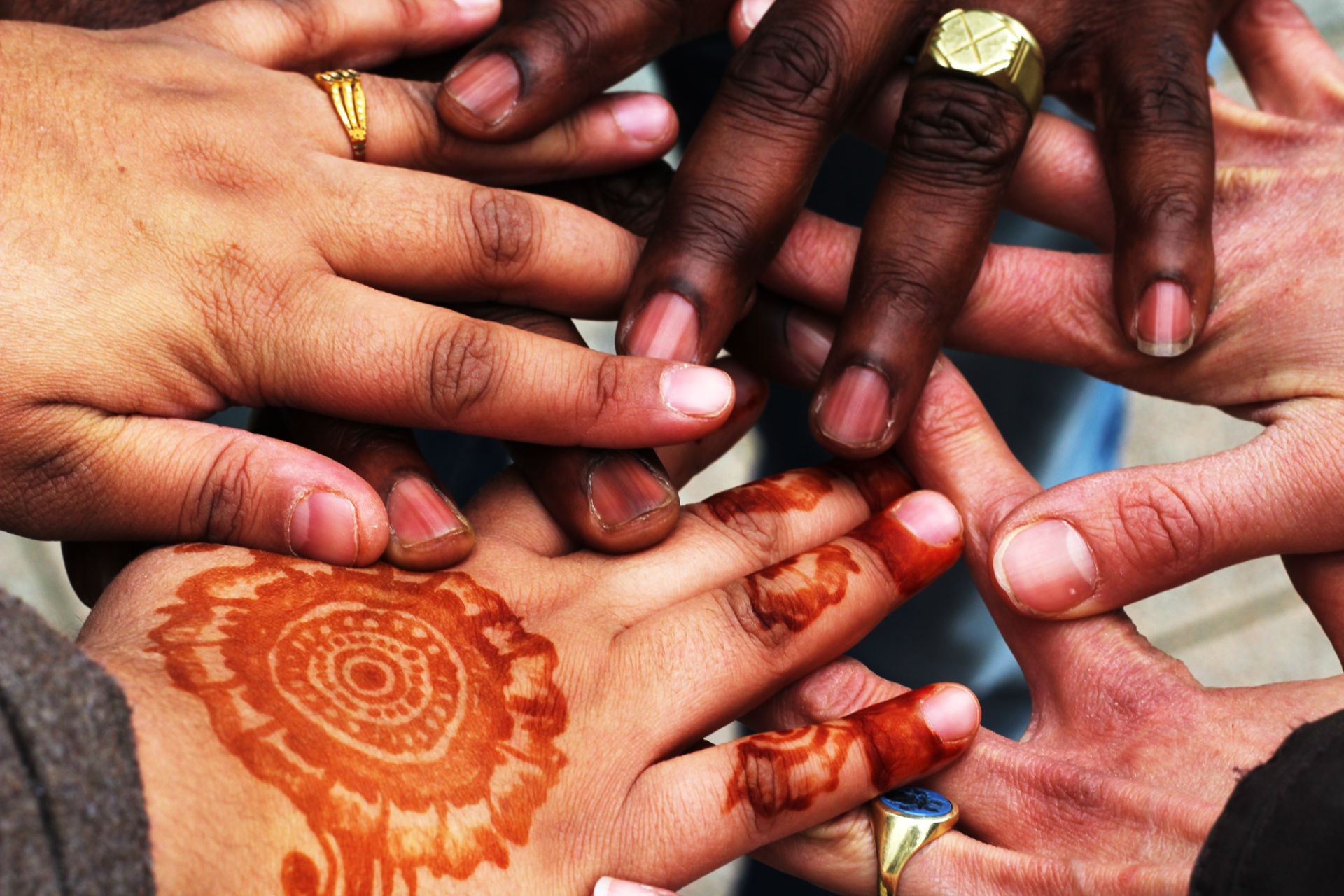 Hände in unterschiedlichsten Hautfarben übereinander.