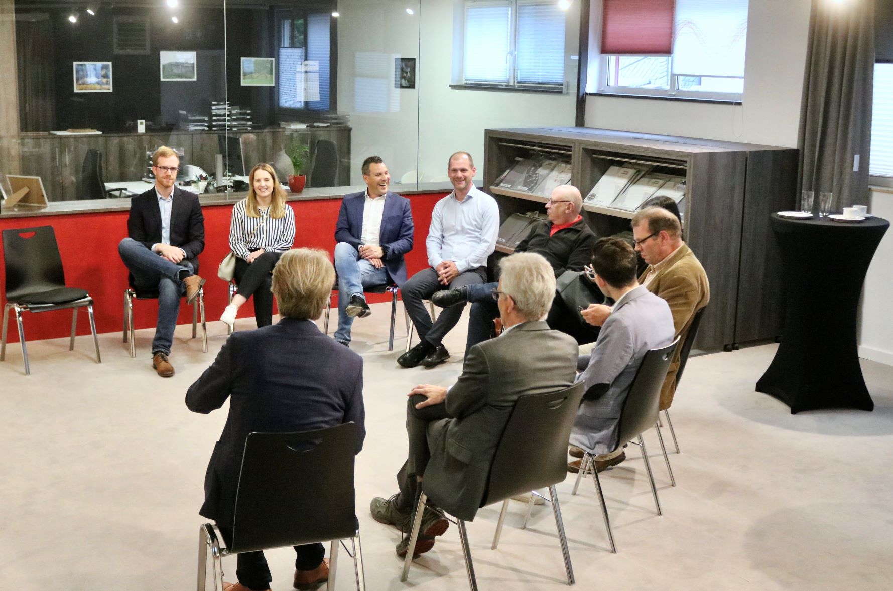 Die Vertreterinnen und Vertreter der Wirtschaftsdelegation und der Firma Donath sitzen gemeinsam in einem Halbkreis und sprechen und lachen miteinander.