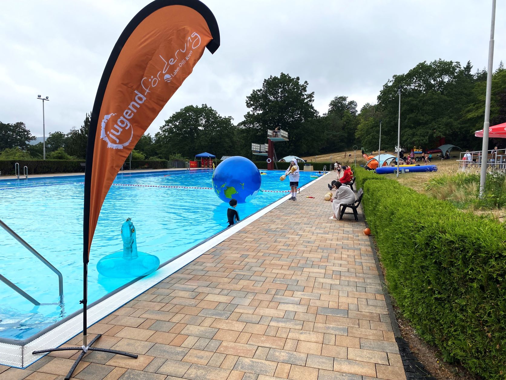 Das Freibad mit vielen Kindern, die Spaß haben.