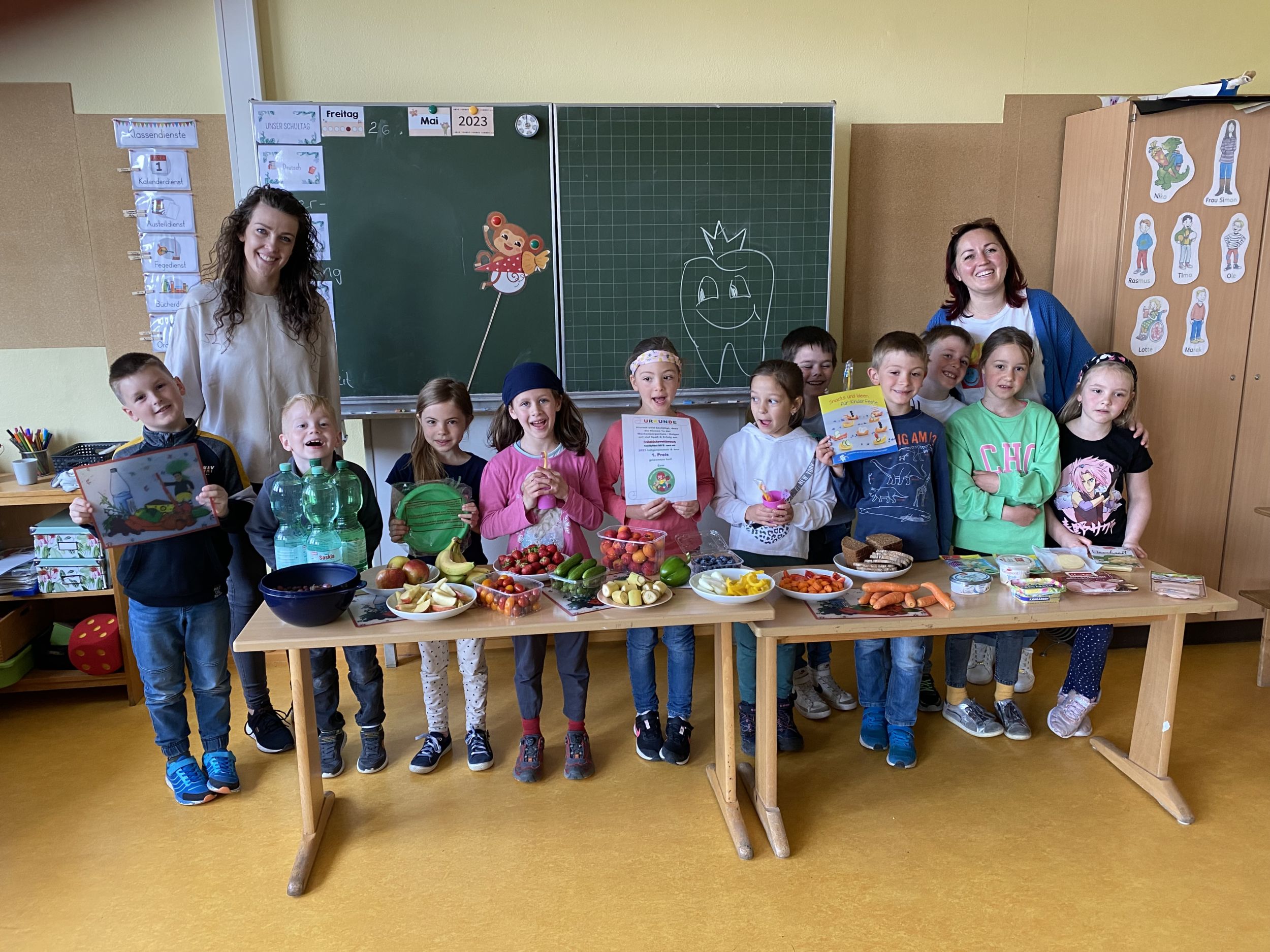 Die Schülerinnen und Schüler der Klasse 1a der Wachenbergschule stehen mit zwei Lehrerinnen vor zwei Tischen, auf denen Frühstück in Brotboxen stehen. Sie können sich über 200 Euro Preisgeld freuen. Foto: Lahn-Dill-Kreis
