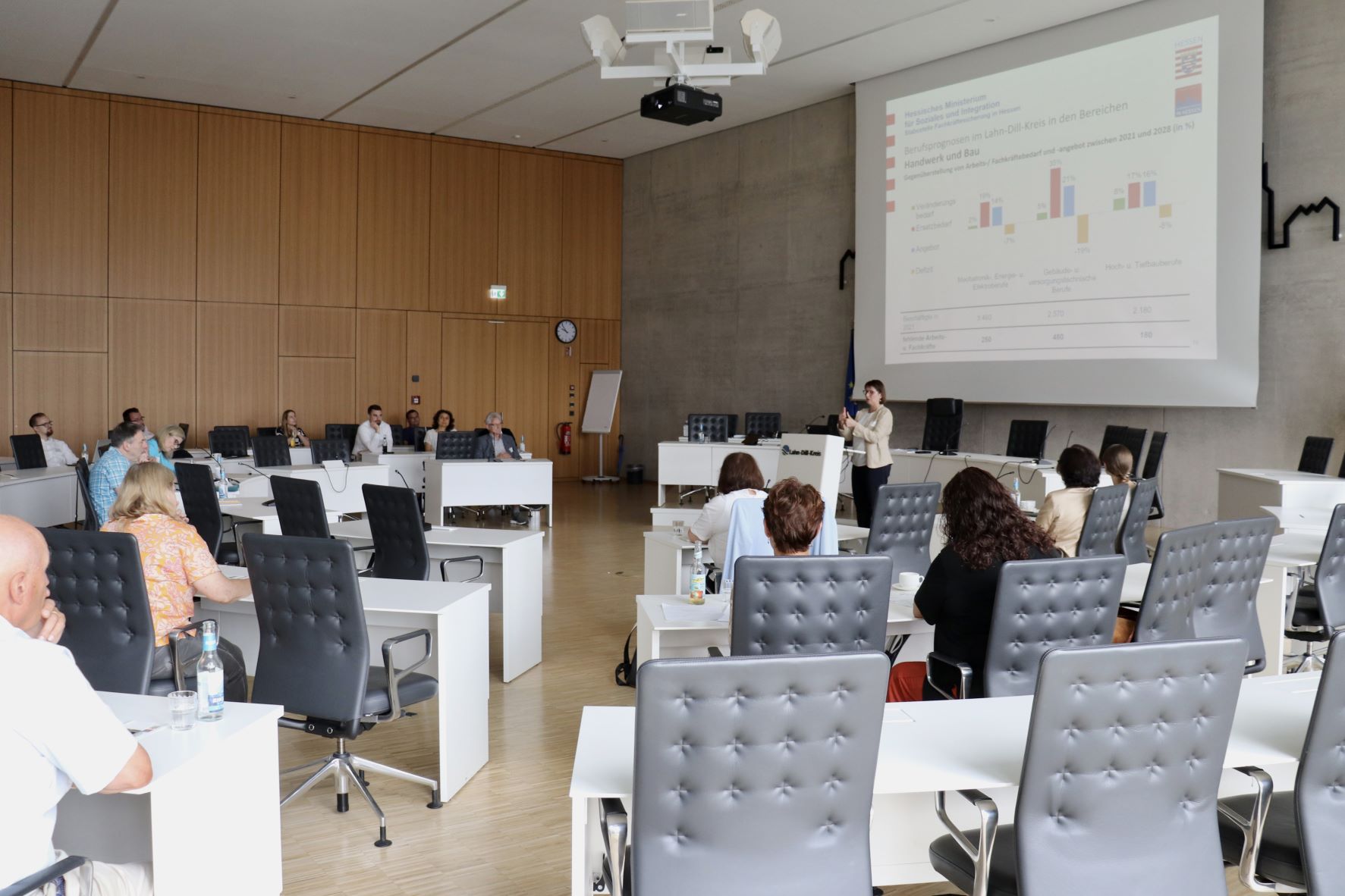 Die Teilnehmenden der Zukunftswerkstatt sitzen im Plenum und hören sich eine Präsentation an.