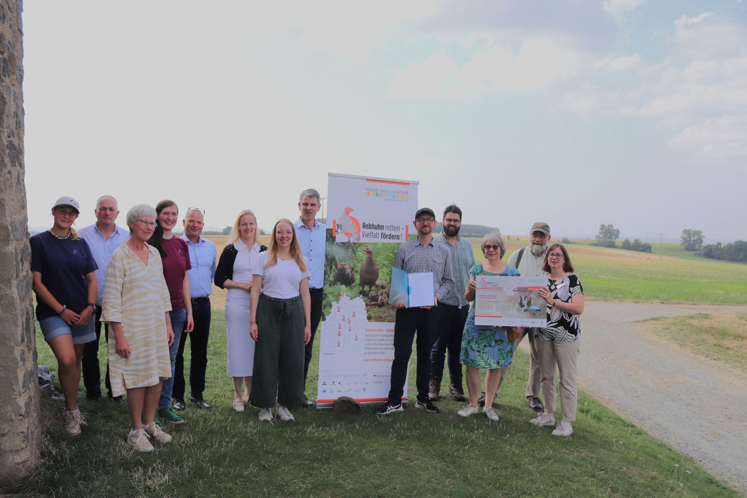 Die Beteiligten der Kooperationsvereinbarung im „Wohnzimmer“ des Rebhuhns im Feldflurprojekt Gießen-Süd (von links): Hannah Zerbe (HGON), Hermann Götz (Fachdienst Landwirtschaft des Wetteraukreises), Margot Schäfer (Abteilung für den ländlichen Raum für den Lahn-Dill-Kreis und den Landkreis Gießen), Clara Guckenbiehl (HGON), Christian Zuckermann (hauptamtlicher Kreisbeigeordneter des Landkreises Gießen), Birgit Weckler (Erste Kreisbeigeordnete des Wetteraukreises), Annika Werner (Abteilung für den ländlichen Raum für den Lahn-Dill-Kreis und den Landkreis Gießen), Frank Inderthal (Erster Kreisbeigeordneter des Lahn-Dill-Kreises), Dr. Nils Stanik (HGON), Maximilian Mohr (Fachdienst Landwirtschaft des Wetteraukreises), Bettina Schreiner (Regierungspräsidium Gießen), Andreas Mohr (Rebhuhnhegering Wetterau), Antje te Molder (Regierungspräsidium Gießen). Foto: Lahn-Dill-Kreis