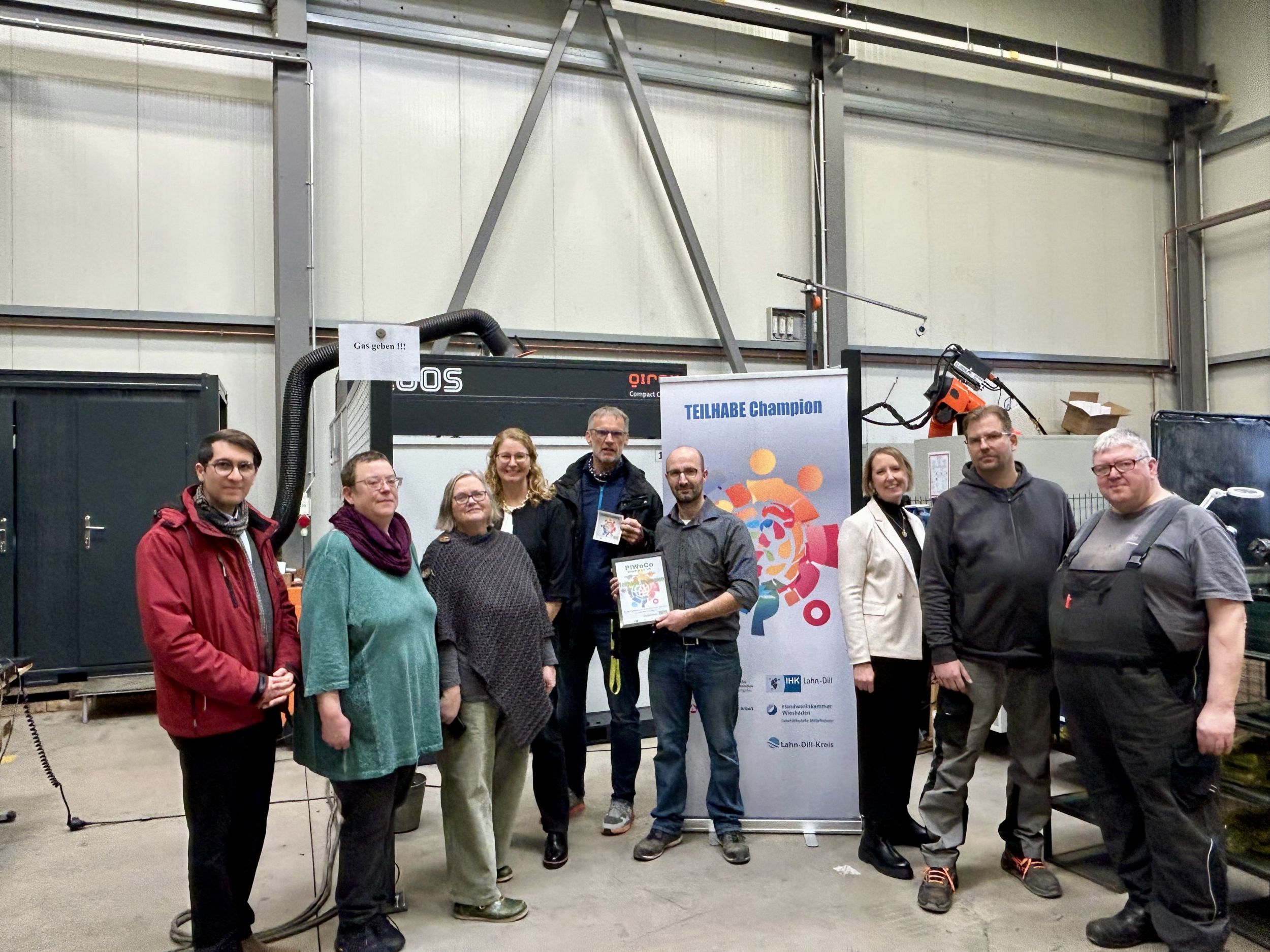 Der Titel „Teilhabechampion“ würdigt monatlich Unternehmen, die sich in besonderem Maße für eine inklusive, vielfältige und chancengerechte Arbeitswelt einsetzen. Im Dezember 2025 wurde die Auszeichnung an PiWeCo verliehen. V. l. n. r.: Burak Dogan, Susanne Eiben, Monika Mundt, Katharina Didlapp, Dirk Köhler, Jan Pitzer, Dr. Rebeecca Neuburger-Hees, Michael Ott, Hans-Joachim Natschke. Foto: Lahn-Dill-Kreis