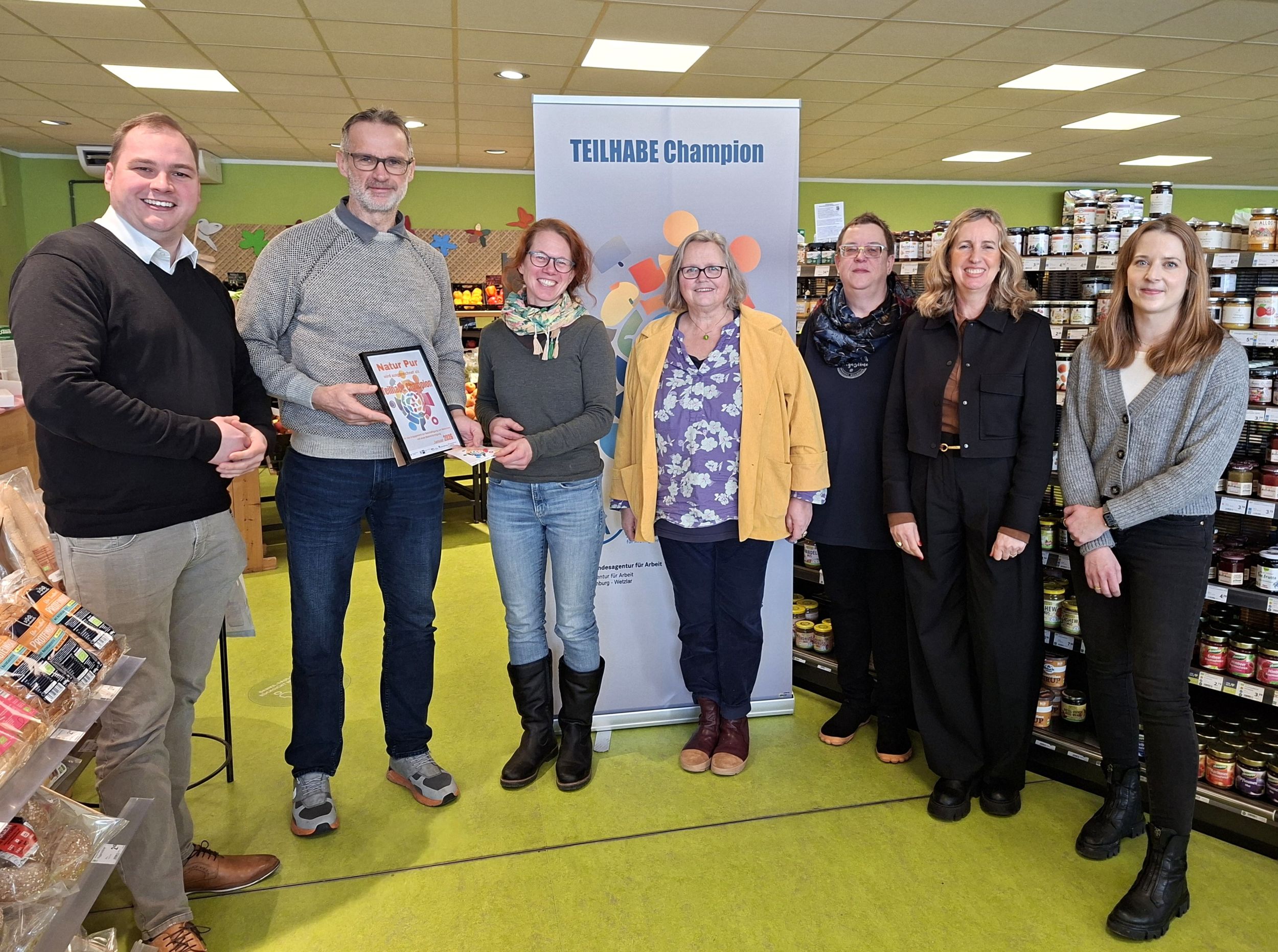 Bildunterschrift: Der Titel „Teilhabechampion“ würdigt monatlich Unternehmen, die sich in besonderem Maße für eine inklusive, vielfältige und chancengerechte Arbeitswelt einsetzen. Im Januar 2026 wurde die Auszeichnung an Natur Pur verliehen. v. l. n. r.: Lukas Winkler, Dirk Köhler, Nicole Besserer, Monika Mundt, Susanne Eiben, Claudia Wagner, Jessica Schaaf. Foto: Lahn-Dill-Kreis