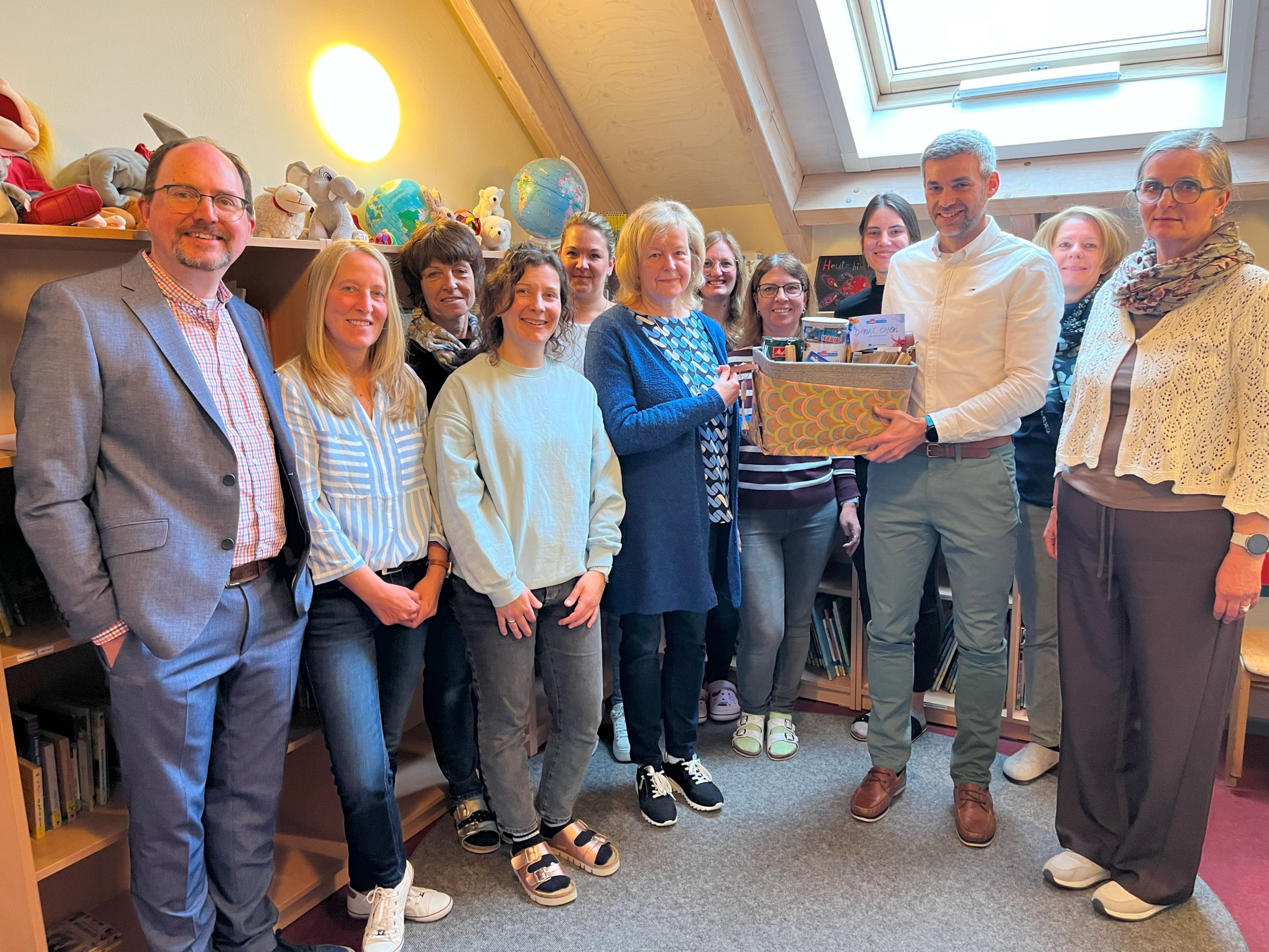 Zum Tag der Kinderbetreuung dankten Fachdienstleiter Andreas Dills (3 v. r.) und die pädagogischen Fachberaterin Regina Herr (rechts) der langjährigen Leiterin der Kita Ewersbach, Anette Müller (6. v. l.) und dem gesamten Kita-Team stellvertretend für alle Beschäftigten in der Kindertagesbetreuung und überreichte einen Präsentkorb. Foto: Lahn-Dill-Kreis